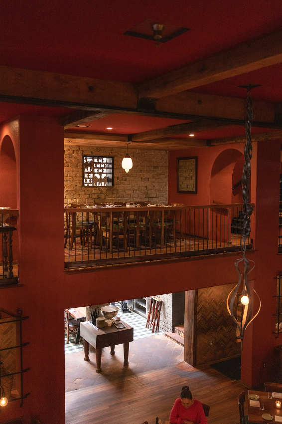 Two-story view showing mezzanine dining area with red walls and ceiling above and in main dining room below